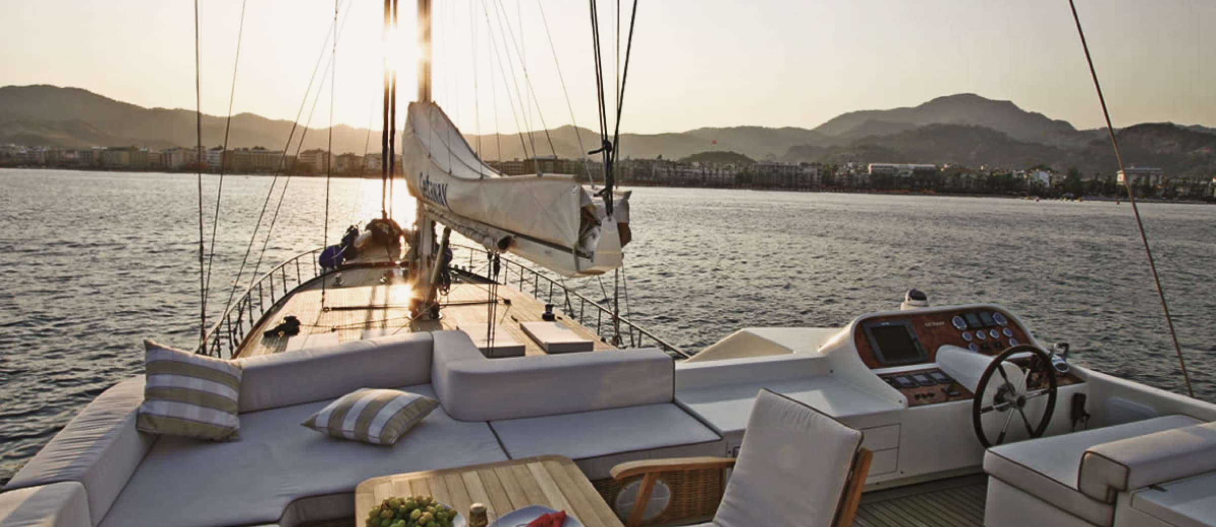 Golden-hour light over the teak deck of a private gulet at anchor