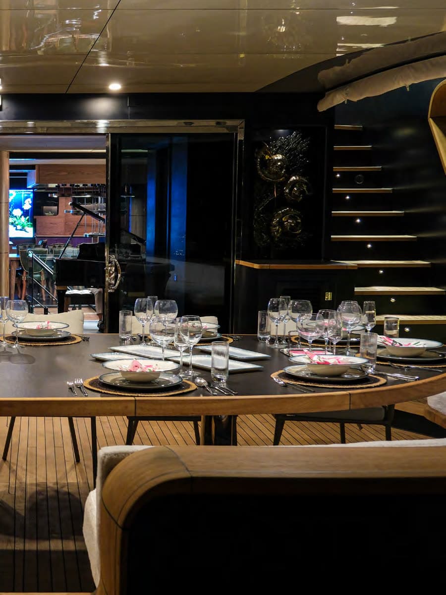 Dinner laid on deck, the grand piano beyond the glass