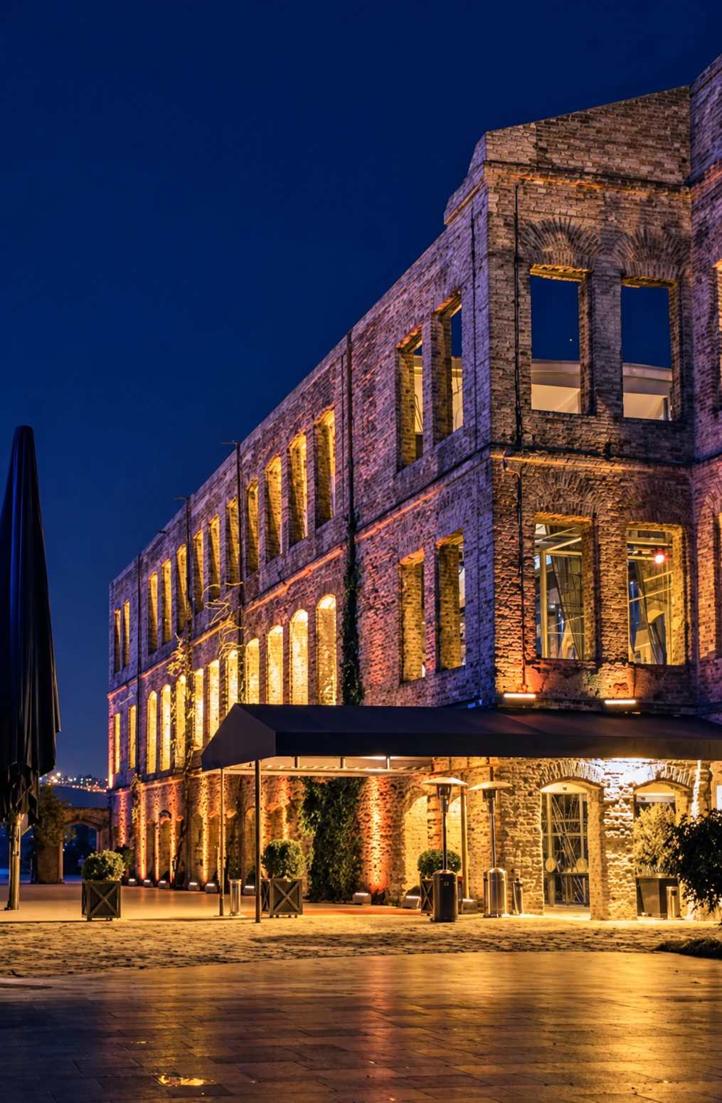 A historic stone waterfront venue glowing with light at night