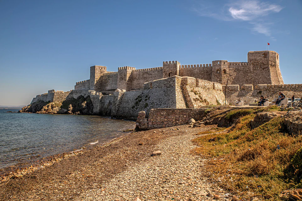 Bozcaada Castle rising above a rocky beach and the Aegean Sea
