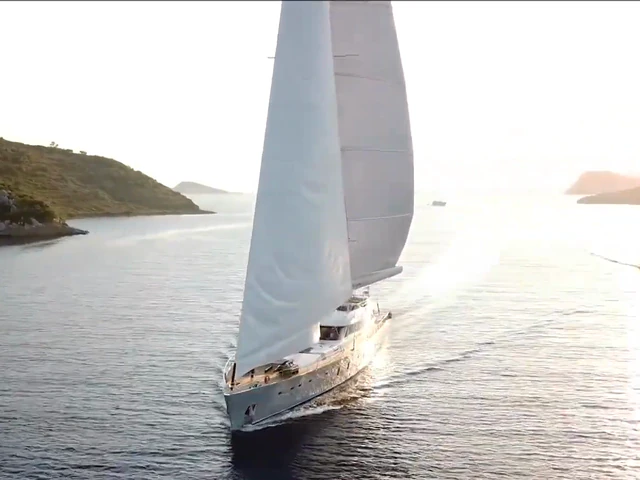 A white 50-metre sailing yacht cruising between quiet coastal islands
