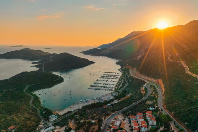 Golden sunset over a sheltered marina and mountain-lined bay