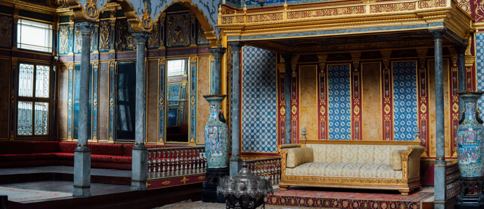 A gilded, canopied hall inside an Ottoman imperial palace in Istanbul.