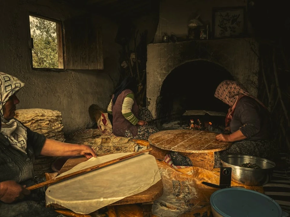 Village cooks rolling flatbread by the hearth, the old Pamphylian way