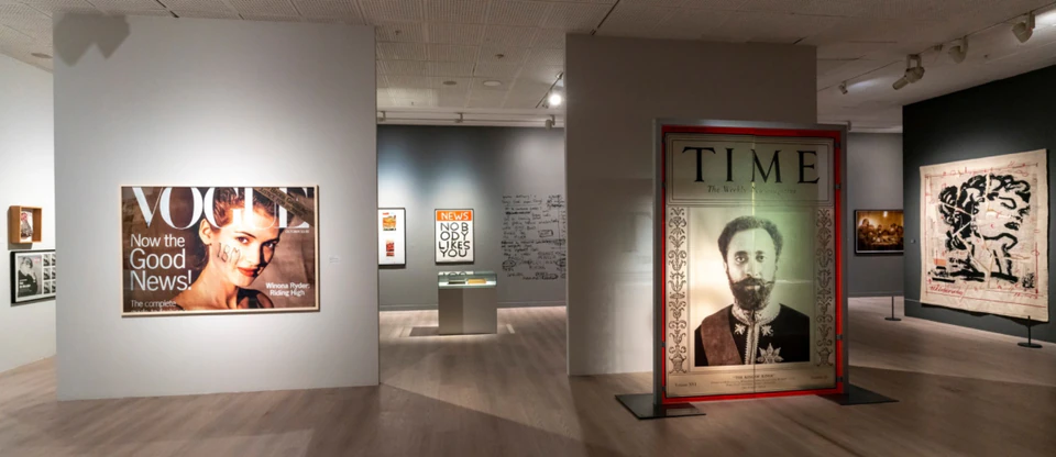 Oversized magazine-cover artworks in a gallery exhibition space.