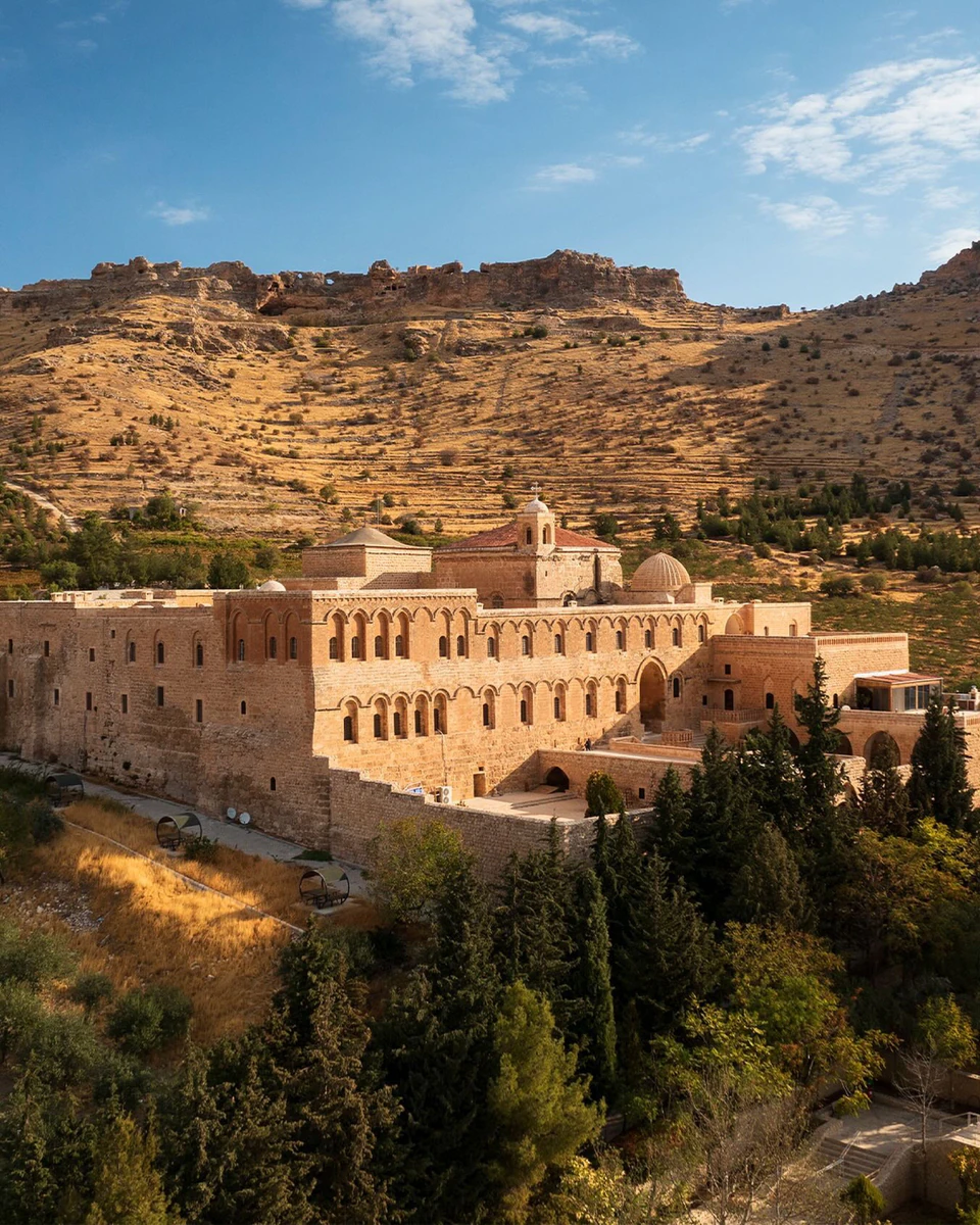 The honey-stone walls of the Deyrulzafaran Monastery glowing against the dry hills outside Mardin