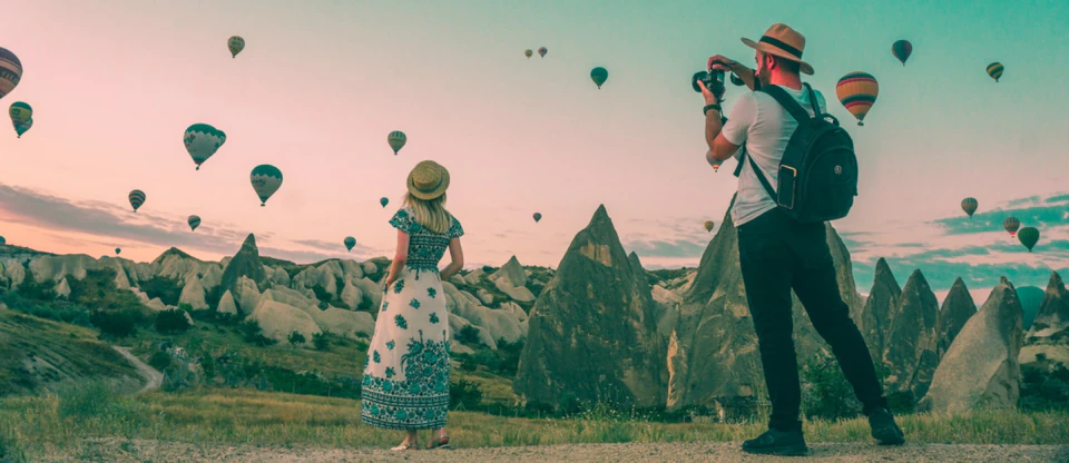 A photographer at a panoramic viewpoint over Cappadocia's valleys