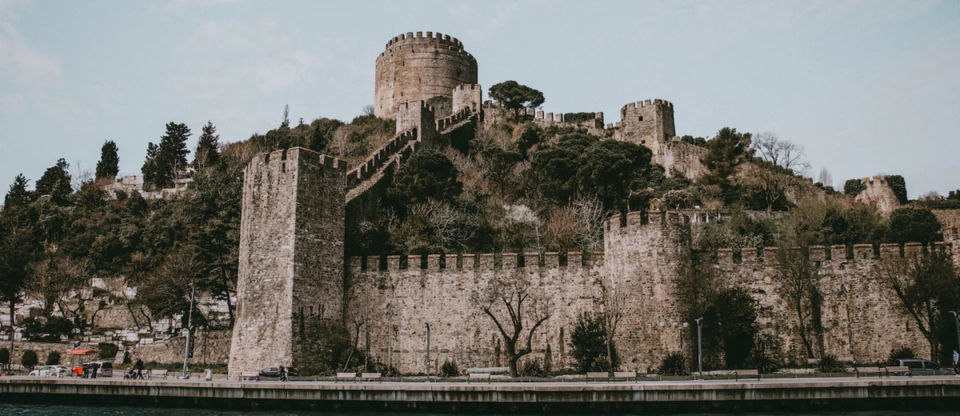 The stone towers and crenellated walls of Rumeli Fortress above the Bosphorus shore.