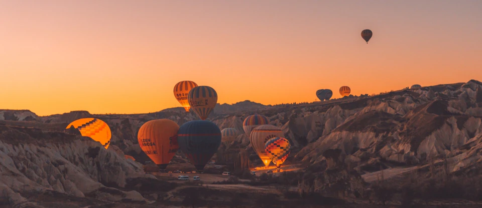 Hundreds of hot air balloons rising over Goreme National Park at sunrise