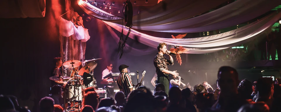 A live band performing to a crowd at a festive evening party