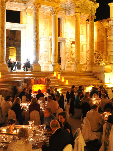 Candlelit dinner tables before the illuminated Library of Celsus at Ephesus