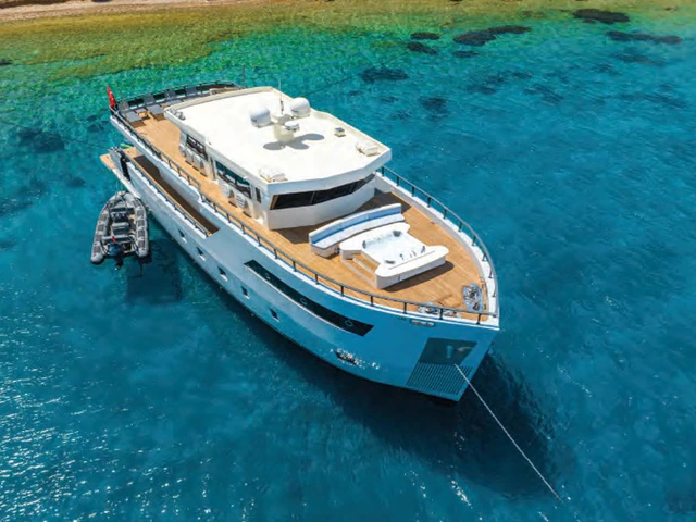 A modern explorer-style motor yacht running through open blue water