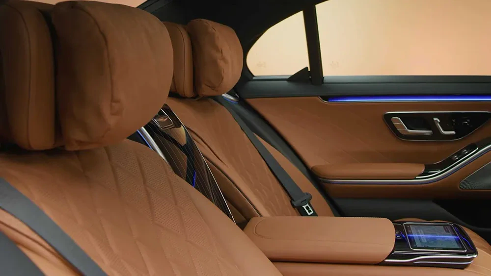 Tan leather rear seats and passenger controls in a luxury Mercedes sedan